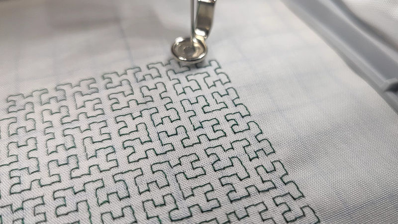 An image of the embroidery machine making the Hilbert curve.