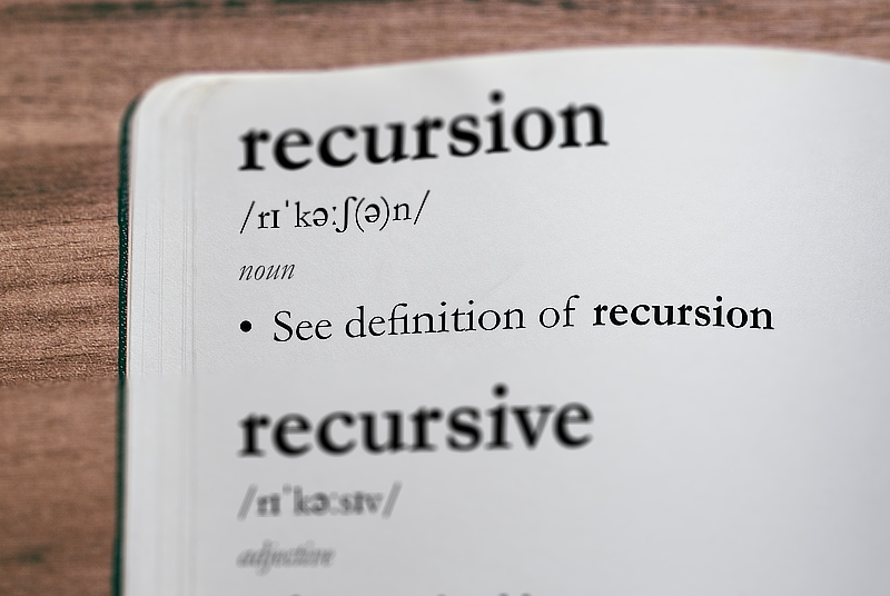Image of a dictionary, focusing on the word "recursion". The definition is: "See definition of recursion".